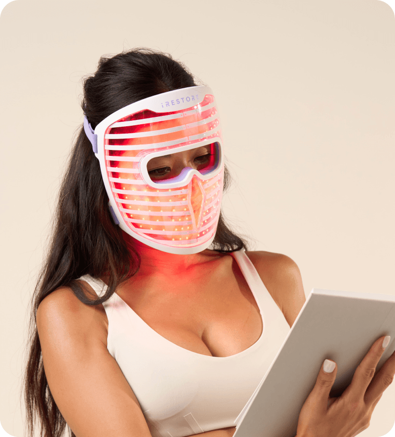 Person reading while wearing the exact iRestore Illumina LED face mask.