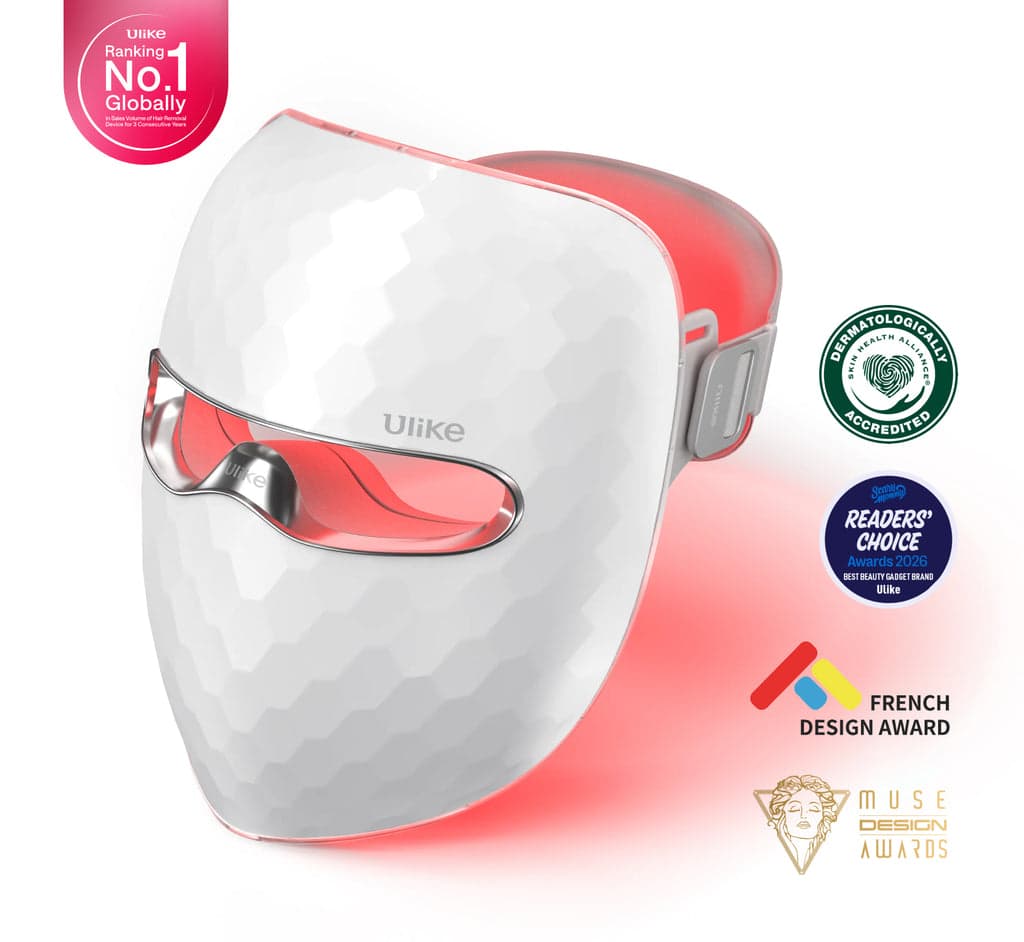 Front three-quarter view of the white Ulike ReGlow UM10 mask illuminated with red light.